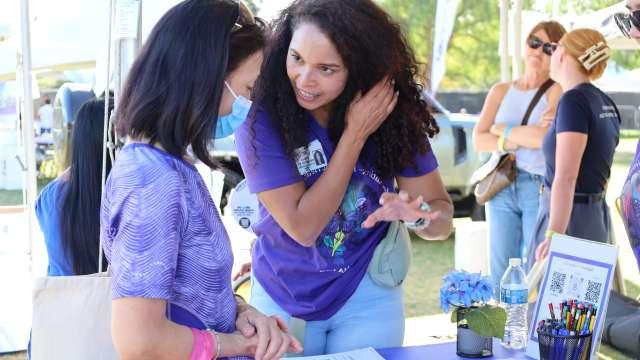 Mirella Diaz-Santos, 博士学位, speaks with a visitor at the Alzheimer’s Los Angeles "Making Memories Festival" at Los Angeles State Historic Park. 