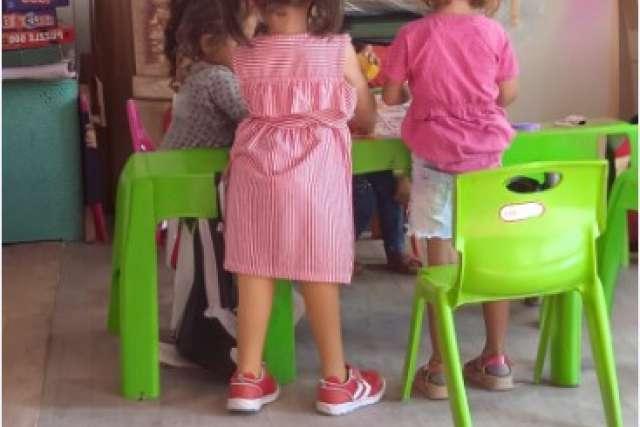 A 5-year-old girl with two prosthetic legs stands at a play table. She lost her mother, father and siblings in the earthquake in Turkey.
