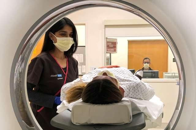 Woman patient with radiologist and scanner