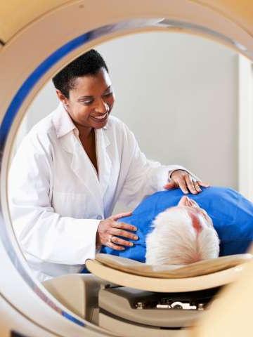 Radiologist preparing patient for PET-CT scanner.